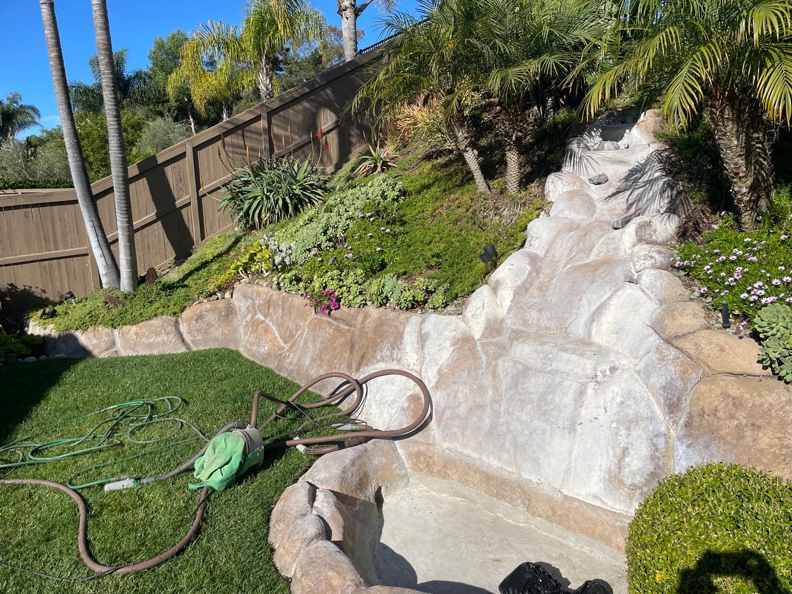 Rock waterfall pool feature cleaning
